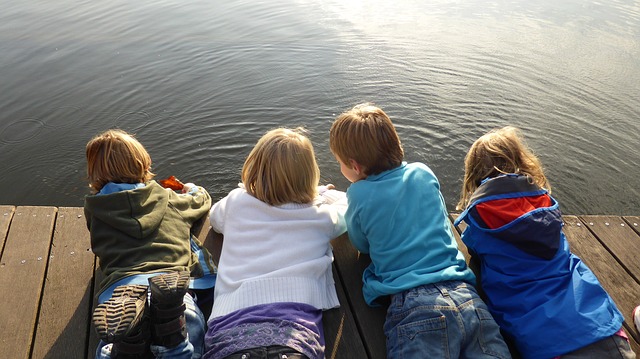 Four children playing together on a dock